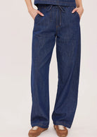 Hayden high-rise barrel-leg pants in washed denim, featuring slash pockets, a front zipper closure, and an elasticated back waistband. Made from a cotton-linen blend for a relaxed, lived-in look.
