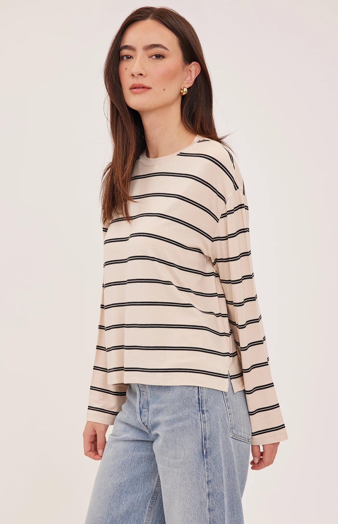 Women's relaxed long sleeve top featuring cream and soft beige stripes, a classic crew neckline, side slits, and a lightweight rayon jersey knit.