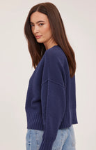 Woman wearing the Gentle Fawn Jennalee Cardigan in Navy, featuring an oversized fit, textured cotton blend knit, front button closure, and exposed seam detailing.