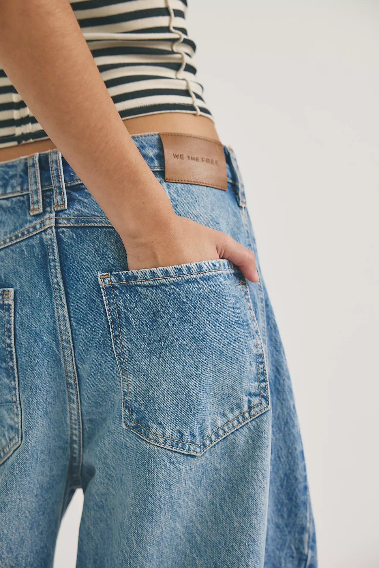 Close-up of blue jeans with a free people brand label
