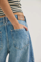 Close-up of blue jeans with a free people brand label