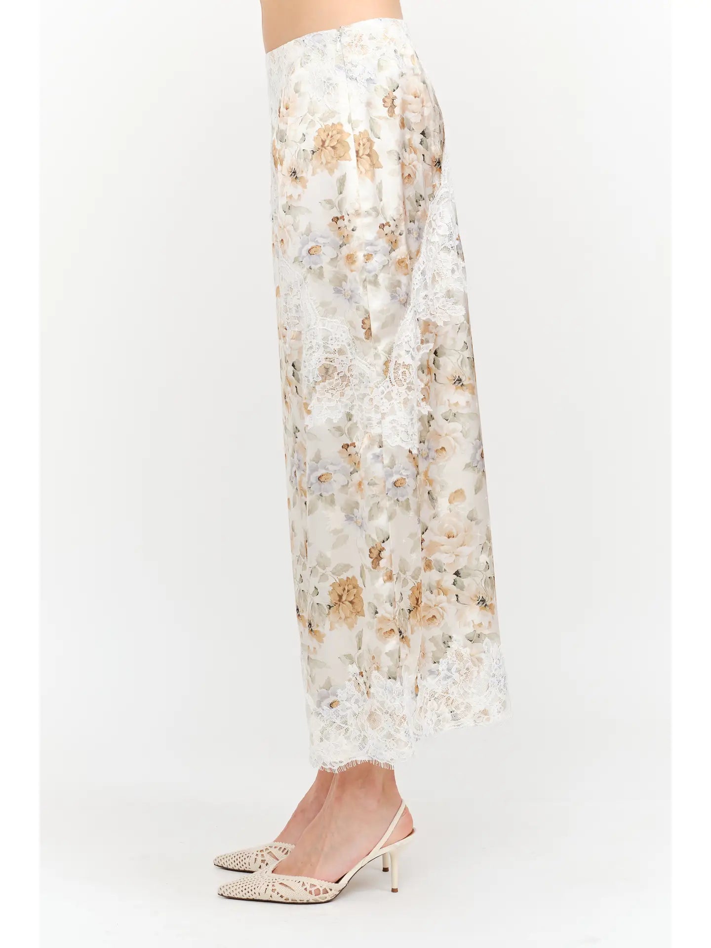 Harper Floral Midi Skirt in soft yellow and cream featuring a delicate floral print, smooth satin finish, white lace panel detailing, and a flowing midi-length silhouette.