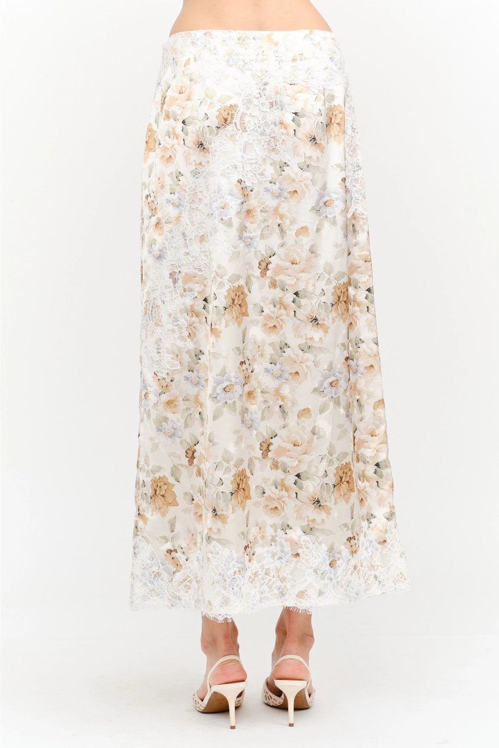 Harper Floral Midi Skirt in soft yellow and cream featuring a delicate floral print, smooth satin finish, white lace panel detailing, and a flowing midi-length silhouette.