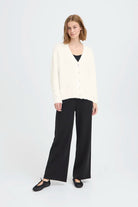 Knit cardigan in a light Cloud Dancer shade featuring a relaxed fit, long sleeves, and a button-front closure with a cozy textured finish.