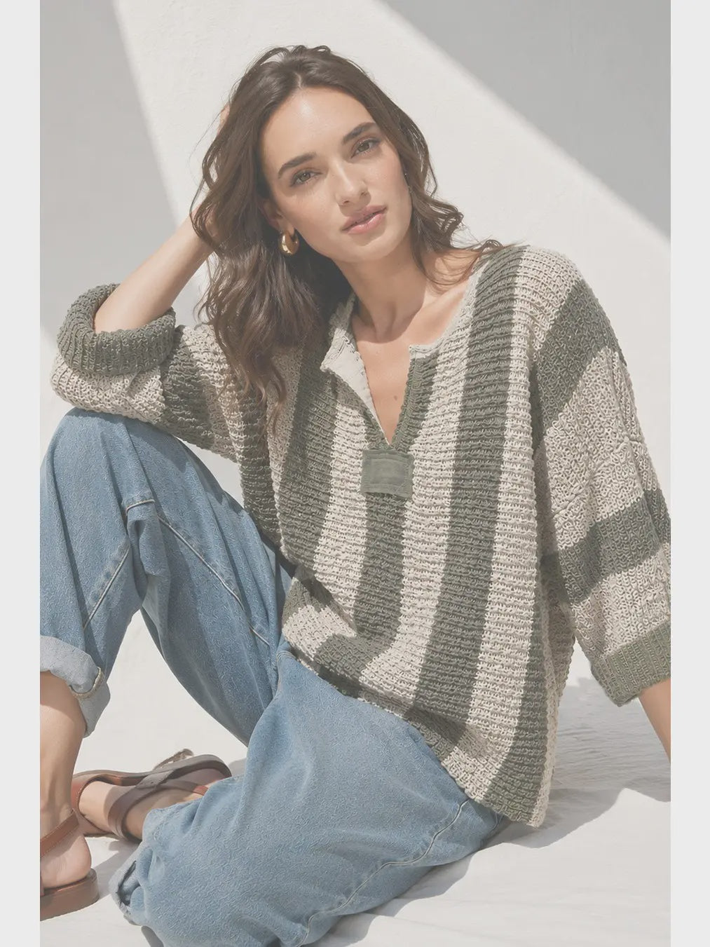 Loose, slouchy fit with a cropped length, V-neckline, 3/4 sleeves, vertical stripe design, and solid front and back patch detailing.