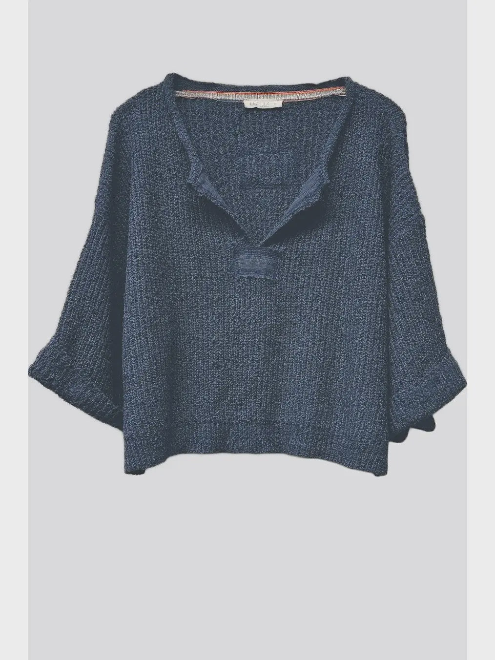 Lora chunky cropped sweater with a loose slouchy fit, V-neckline, relaxed ¾ sleeves, and contrasting solid patch details on the front and back.