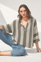 Loose, slouchy fit with a cropped length, V-neckline, 3/4 sleeves, vertical stripe design, and solid front and back patch detailing.