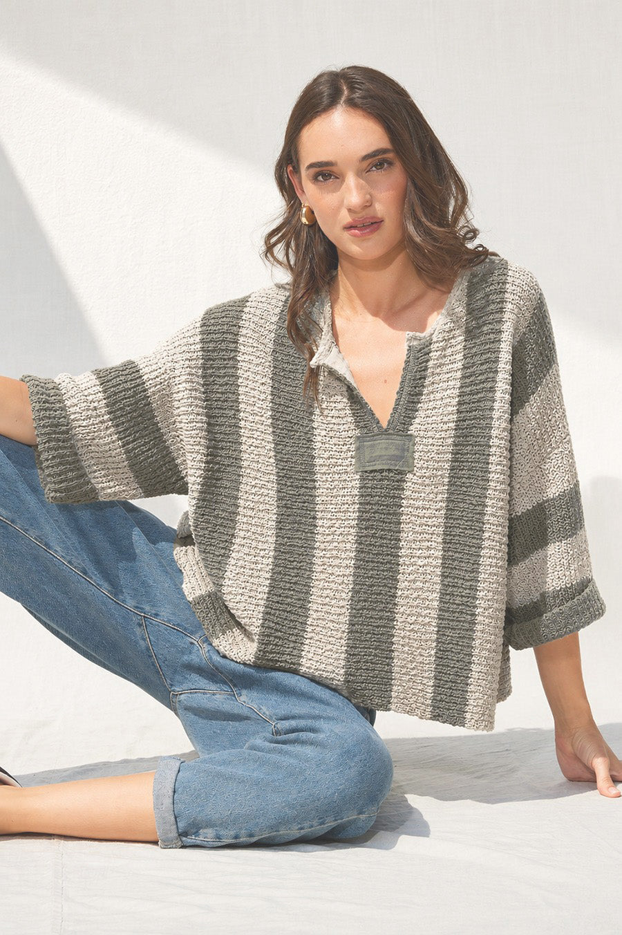 Loose, slouchy fit with a cropped length, V-neckline, 3/4 sleeves, vertical stripe design, and solid front and back patch detailing.