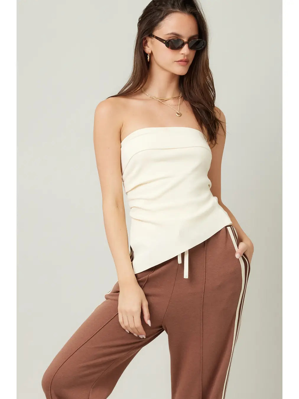 woman wearing a cream strapless asymmetrical top 