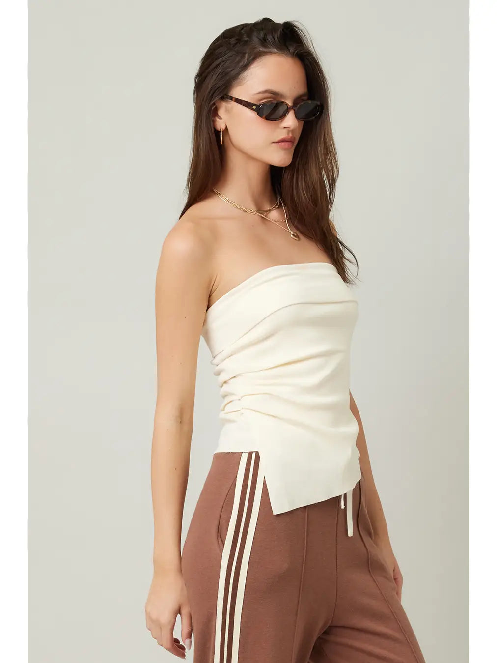 woman wearing a cream strapless asymmetrical top 