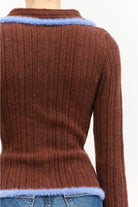 Model wearing the Jacquie Knit Top in brown, featuring a fitted silhouette, long sleeves, collared neckline, contrasting blue fuzzy trim, and two-way front zipper closure.