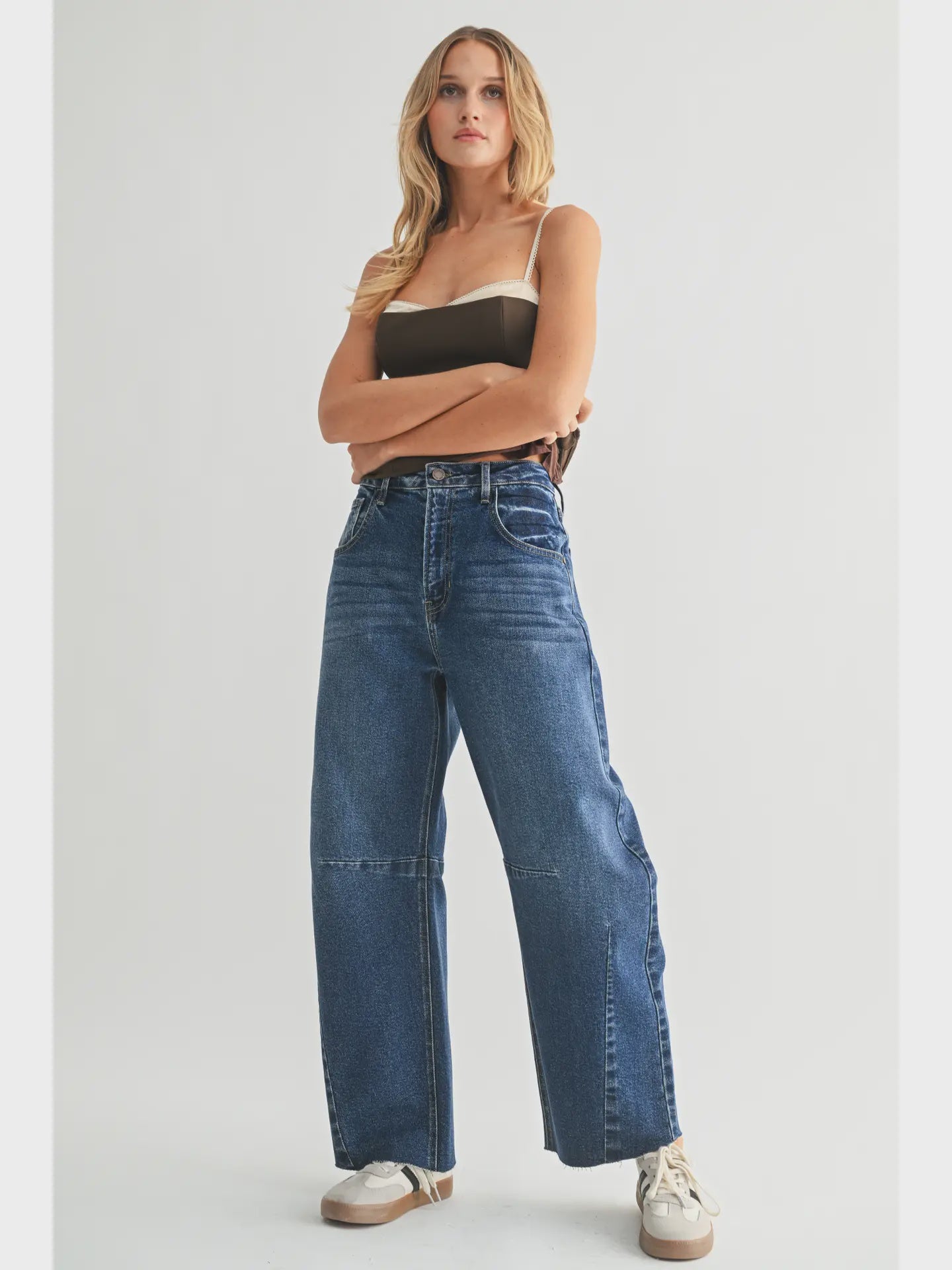 Dark denim barrel-leg jeans with an extra-wide silhouette, high rise, statement seam detailing, subtle whiskering, and silver hardware.
