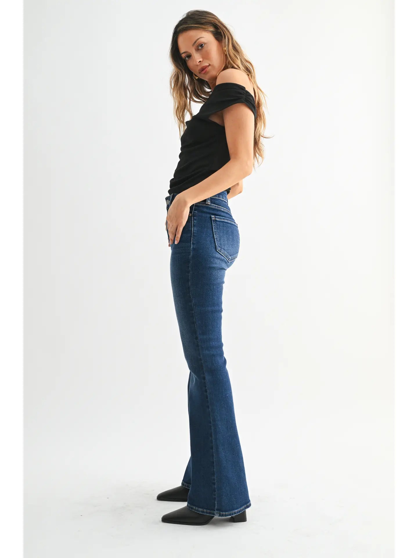 Dark denim mid-rise flare jeans with a fitted waist, hips, and thighs and a full-length leg that opens into a sleek, flattering flare.
