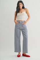 woman wearing an ankle length barrel jean in a navy and white ginham print
