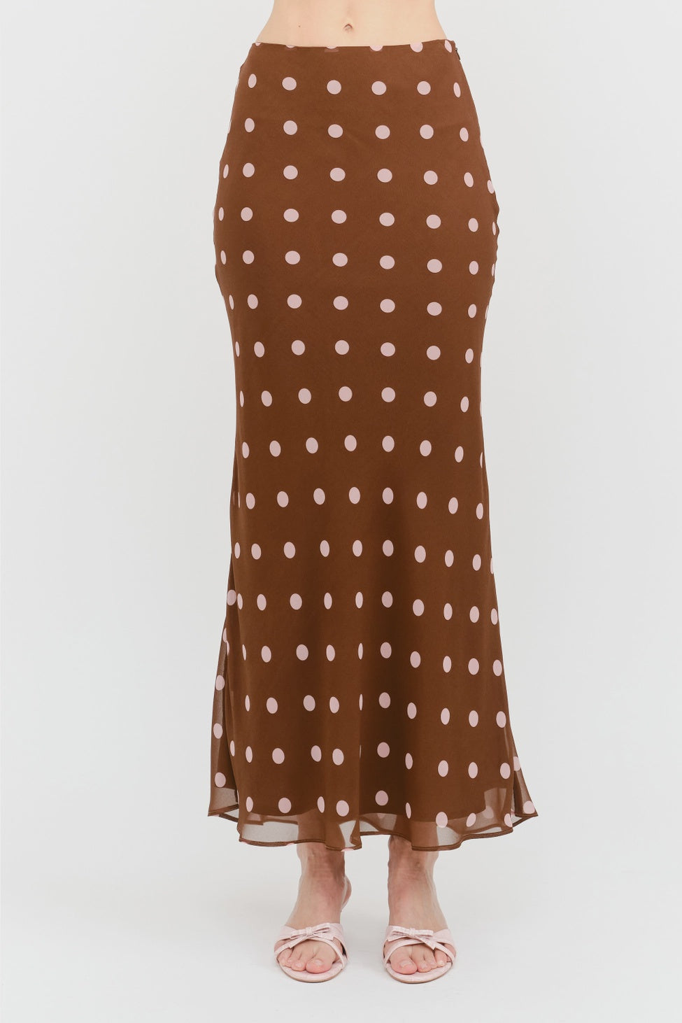 Kalila Midi Skirt in rich brown featuring soft pink polka dots, a flattering mermaid silhouette, and a flowing ankle-grazing hem.