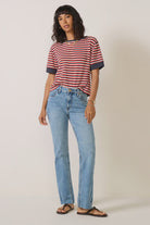 Light-to-medium blue high-rise jeans with a slim fit through the hips and thighs, subtle flared legs, classic five-pocket styling, and raw-cut hems.
