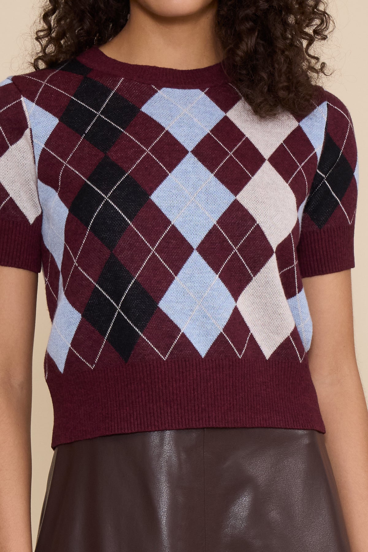 Bria Argyle Top in Burgundy Multi featuring a burgundy, blue, black, and neutral argyle pattern, short sleeves, and crew neckline.