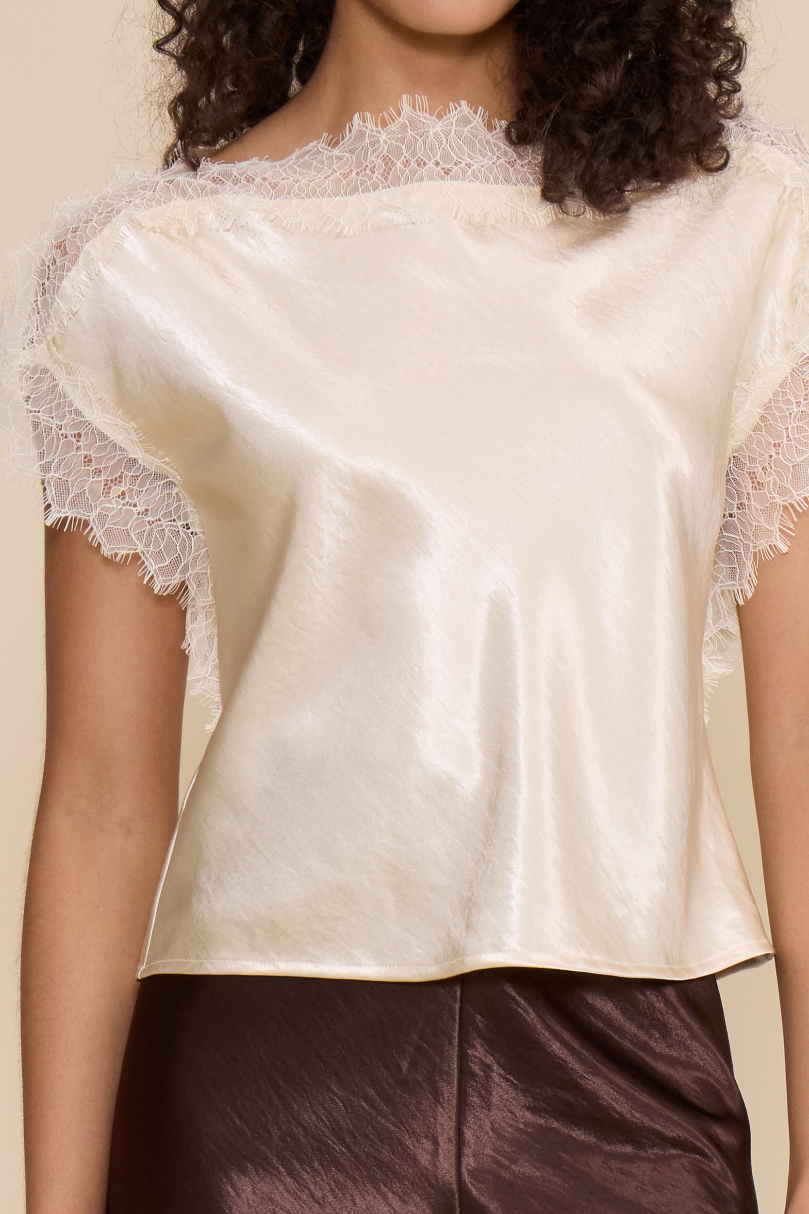 Lucy Paris Chris Lace Trim Top in ivory featuring a silky finish, relaxed fit, and delicate sheer lace trim along the neckline and short sleeves.