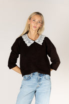 Knit sweater featuring a delicate lace collar, long sleeves, and a relaxed silhouette for a feminine, layered look.
