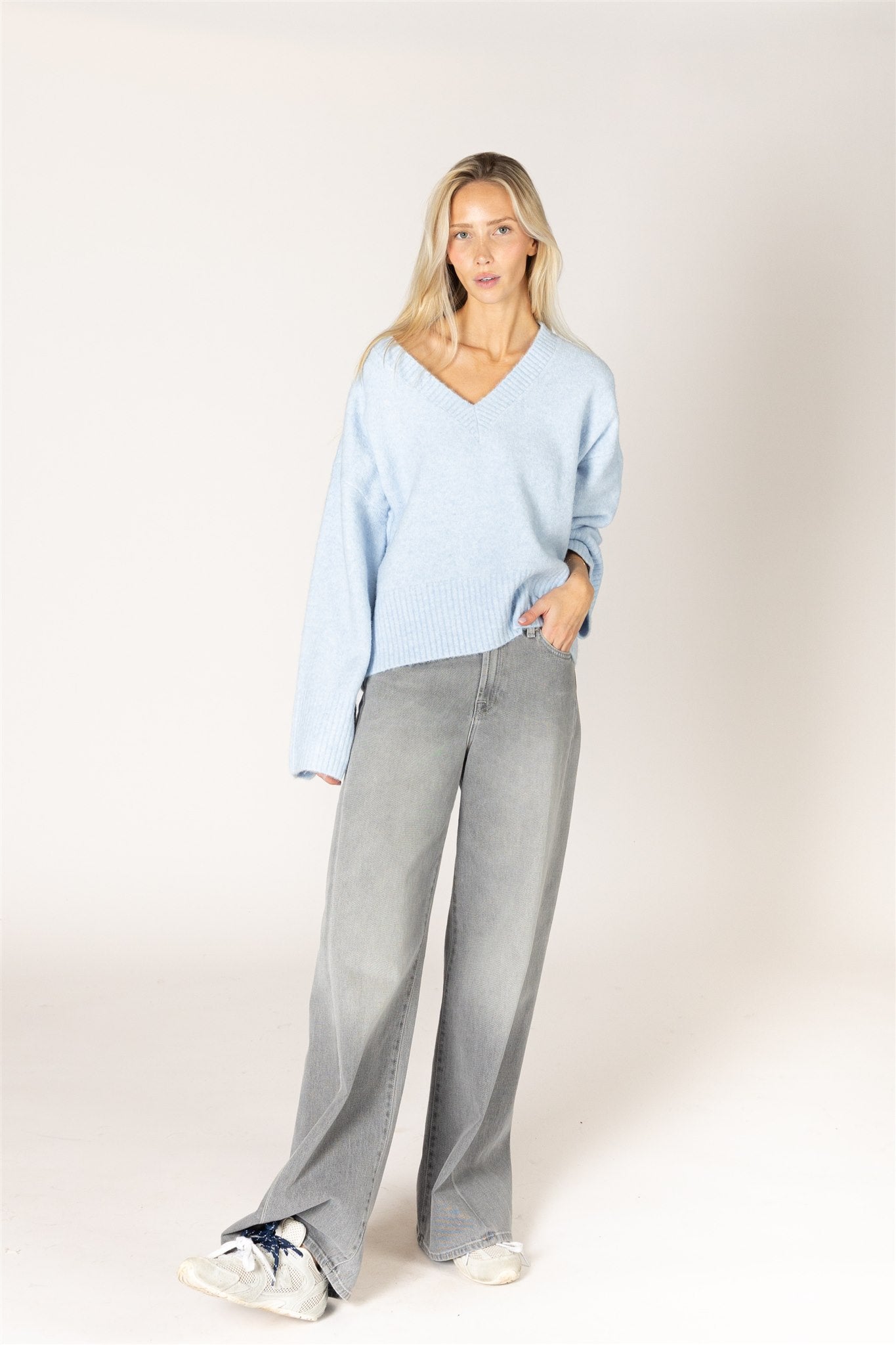 Breeze blue V-neck sweater in a lightweight knit, featuring a relaxed fit, long sleeves, and ribbed trim at the neckline, cuffs, and hem.