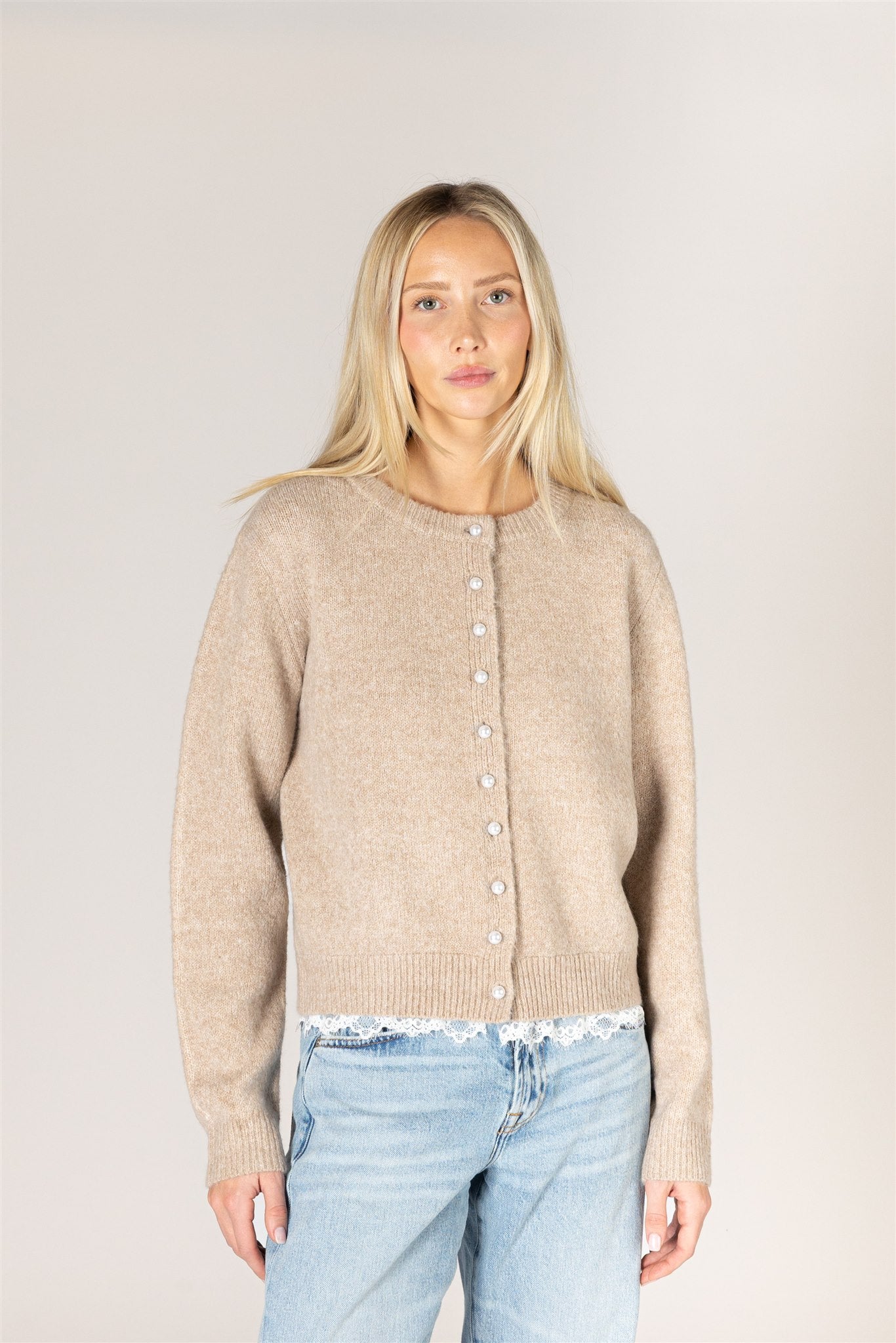 Lightweight knit cardigan featuring a classic crew neckline, button-front closure, long sleeves, and delicate lace trim along the hem and cuffs.
