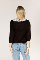 Knit sweater featuring a delicate lace collar, long sleeves, and a relaxed silhouette for a feminine, layered look.
