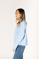 Sky blue ribbed knit sweater featuring a mock neckline, relaxed fit, and long sleeves.
