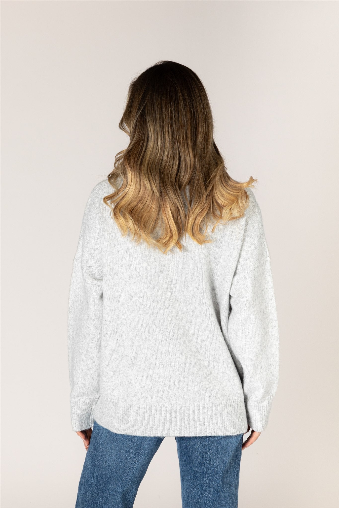 Ash grey crewneck sweater featuring a pale lemonade heart appliqué with contrast whipstitch detailing, long sleeves, and ribbed cuffs, hem, and neckline.