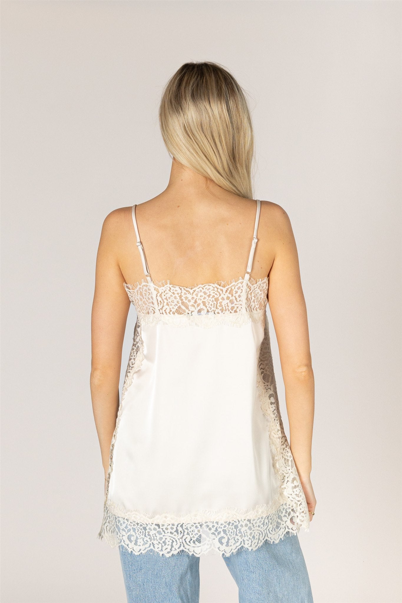 Ivory lace trim camisole top with delicate lace detailing at the neckline and hem.