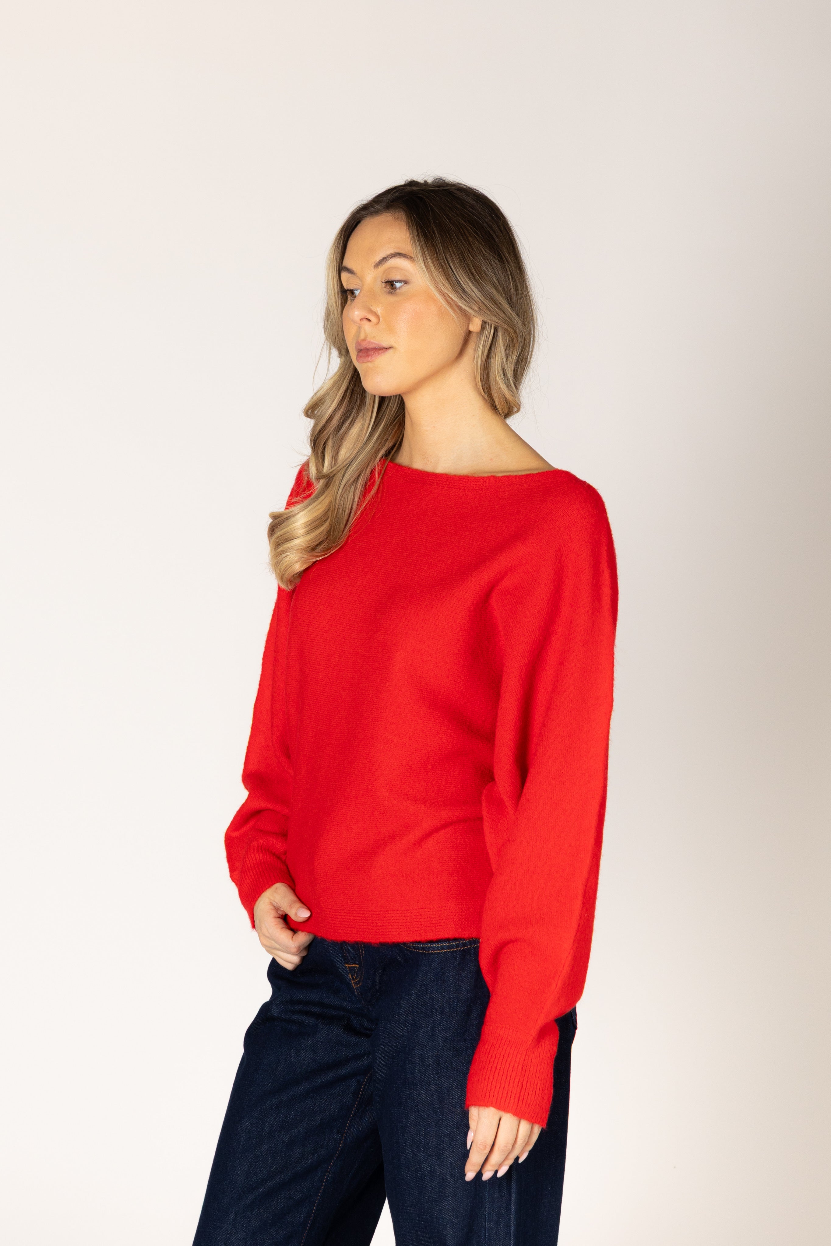 Off-the-shoulder knit sweater in a neutral tone, featuring a relaxed silhouette and wide neckline for an elegant, effortless look.