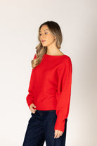 Off-the-shoulder knit sweater in a neutral tone, featuring a relaxed silhouette and wide neckline for an elegant, effortless look.