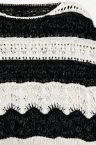The Elowyn Open-Stitch Sweater in cream and black, featuring a sheer crochet-inspired texture and semi-cropped silhouette.

