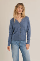 Short knit cardigan featuring long sleeves, a lace-trimmed V-neckline, and a full-length front button closure.