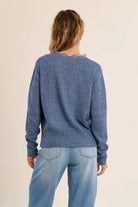 Short knit cardigan featuring long sleeves, a lace-trimmed V-neckline, and a full-length front button closure.