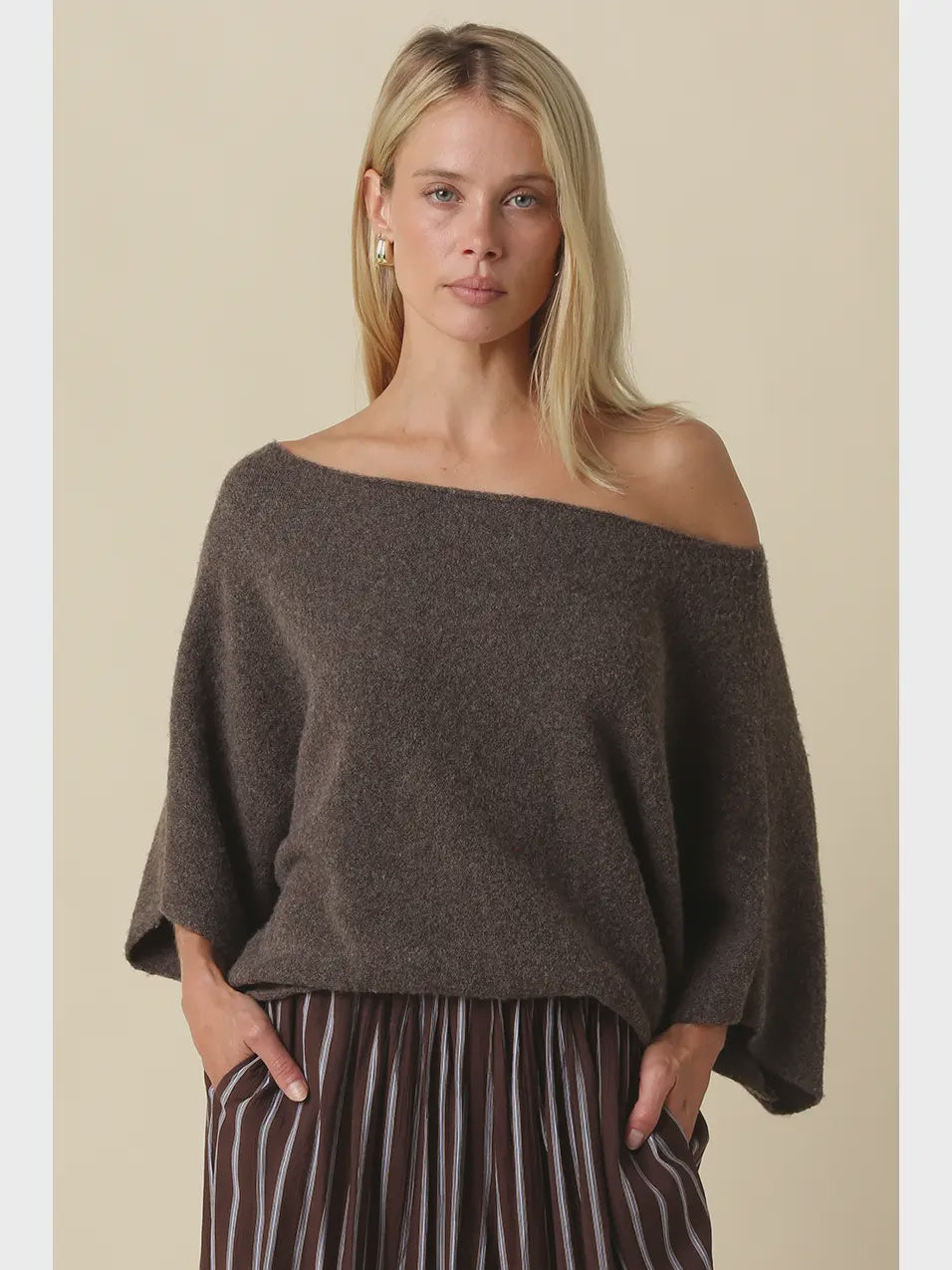 Oversized knit top with a one-shoulder neckline, dolman sleeves, textured finish, and relaxed draped fit.