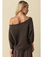 Oversized knit top with a one-shoulder neckline, dolman sleeves, textured finish, and relaxed draped fit.