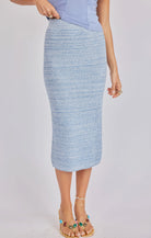Person wearing a light blue textured skirt on a plain background