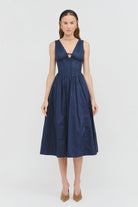 Shae Poplin Midi Dress in navy featuring a corset-inspired fitted bodice, plunging V-neckline, gathered bust with tie-front detail, defined waist, and full midi-length skirt.