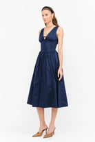 Shae Poplin Midi Dress in navy featuring a corset-inspired fitted bodice, plunging V-neckline, gathered bust with tie-front detail, defined waist, and full midi-length skirt.