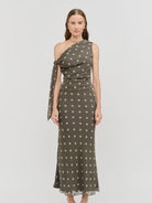 Celestine Off The Shoulder Top featuring a lightweight chiffon fabric with a contrasting polka dot print, asymmetrical one-shoulder neckline, soft draped detailing, and an elegant side tie. Designed with a flattering, feminine silhouette and a slightly relaxed fit.
