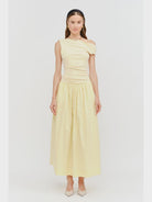 woman wearing sleeveless off the shoulder maxi butter yellow dress