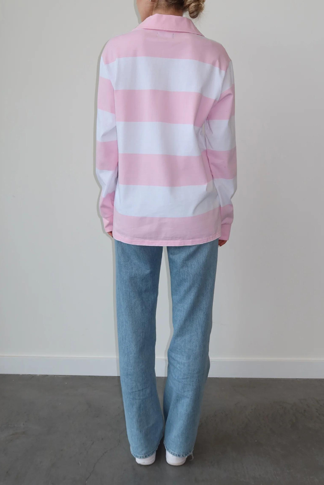 Brunette The Label The "HEART" Striped Rugby Shirt. Feel the love wherever you go in the "Heart" Striped Rugby Shirt in Baby Pink and White. It features bold stripes and a ribbed collar and sleeves. We recommend sizing up for a more oversized fit. 