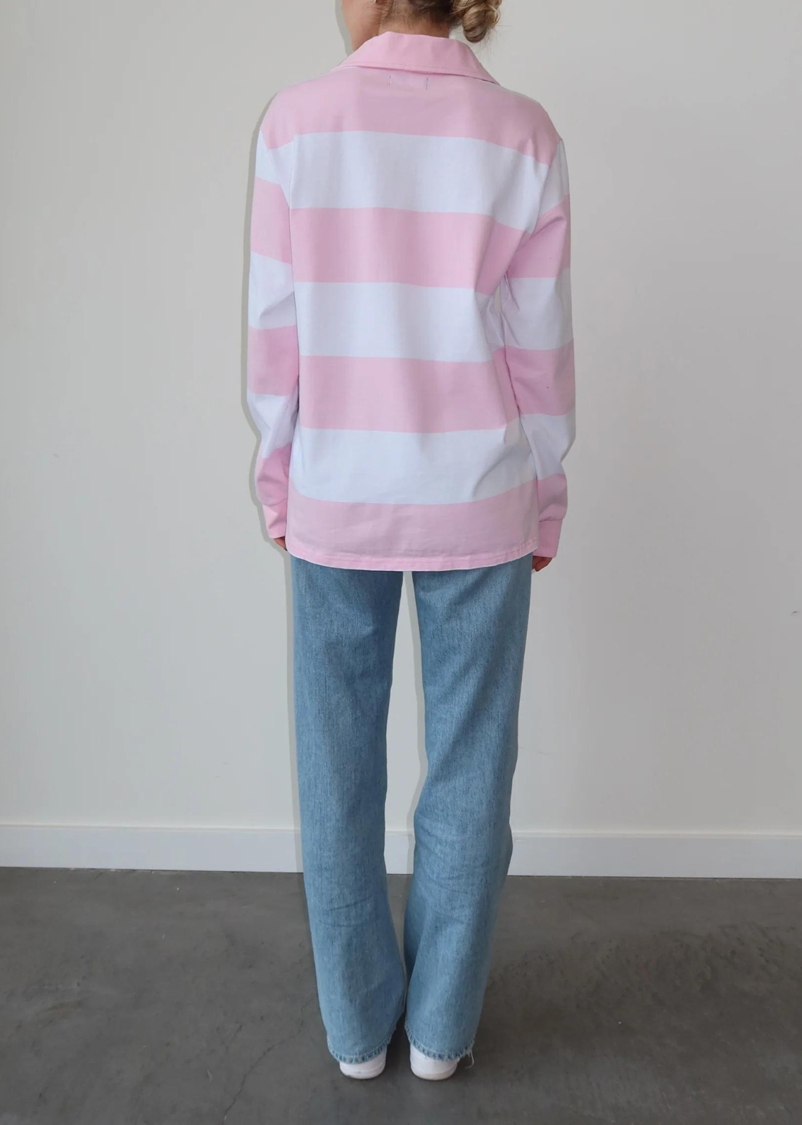 Brunette The Label The "HEART" Striped Rugby Shirt. Feel the love wherever you go in the "Heart" Striped Rugby Shirt in Baby Pink and White. It features bold stripes and a ribbed collar and sleeves. We recommend sizing up for a more oversized fit. 