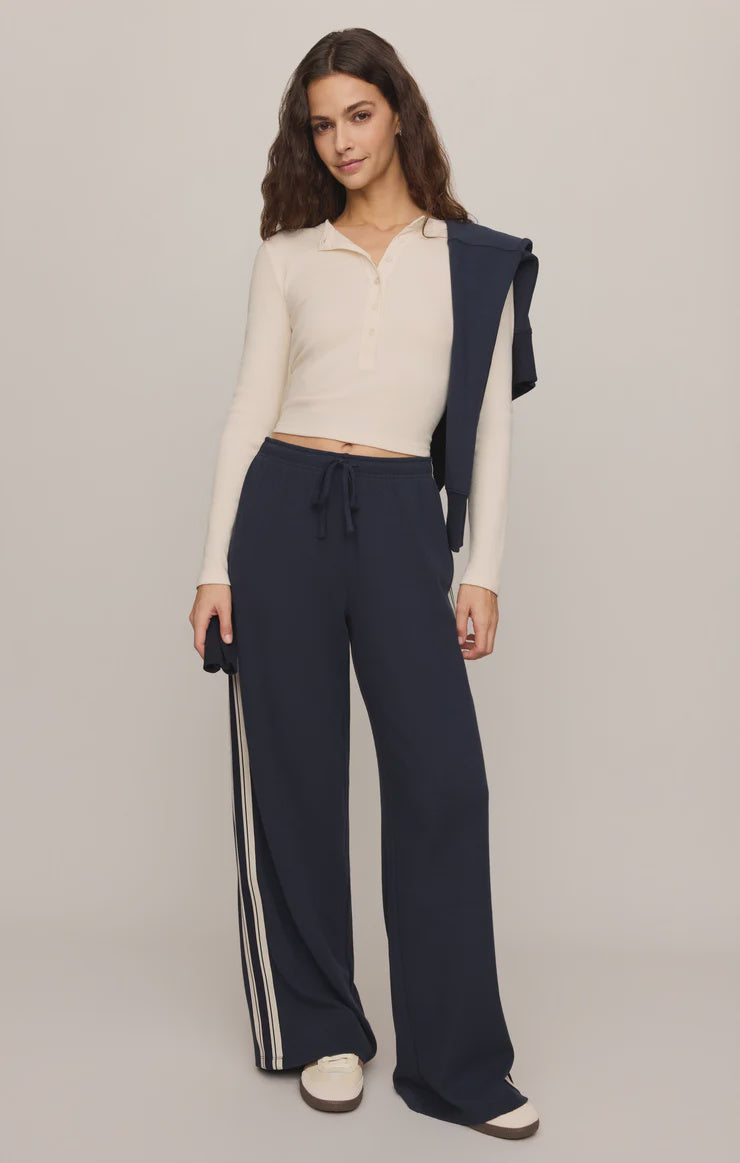 Fitted long-sleeve henley top in soft cotton modal rib fabric with a cropped silhouette, henley neckline, and functional button-front placket. The comfortable stretch fabric creates a flattering fit, making it ideal for casual wear, layering, or pairing with workout-inspired outfits.
