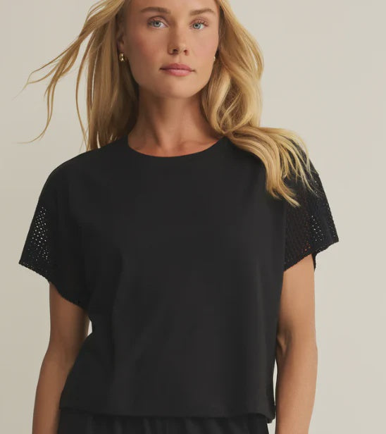 woman wearing black short sleeve top with crochet detailing on the sleeves