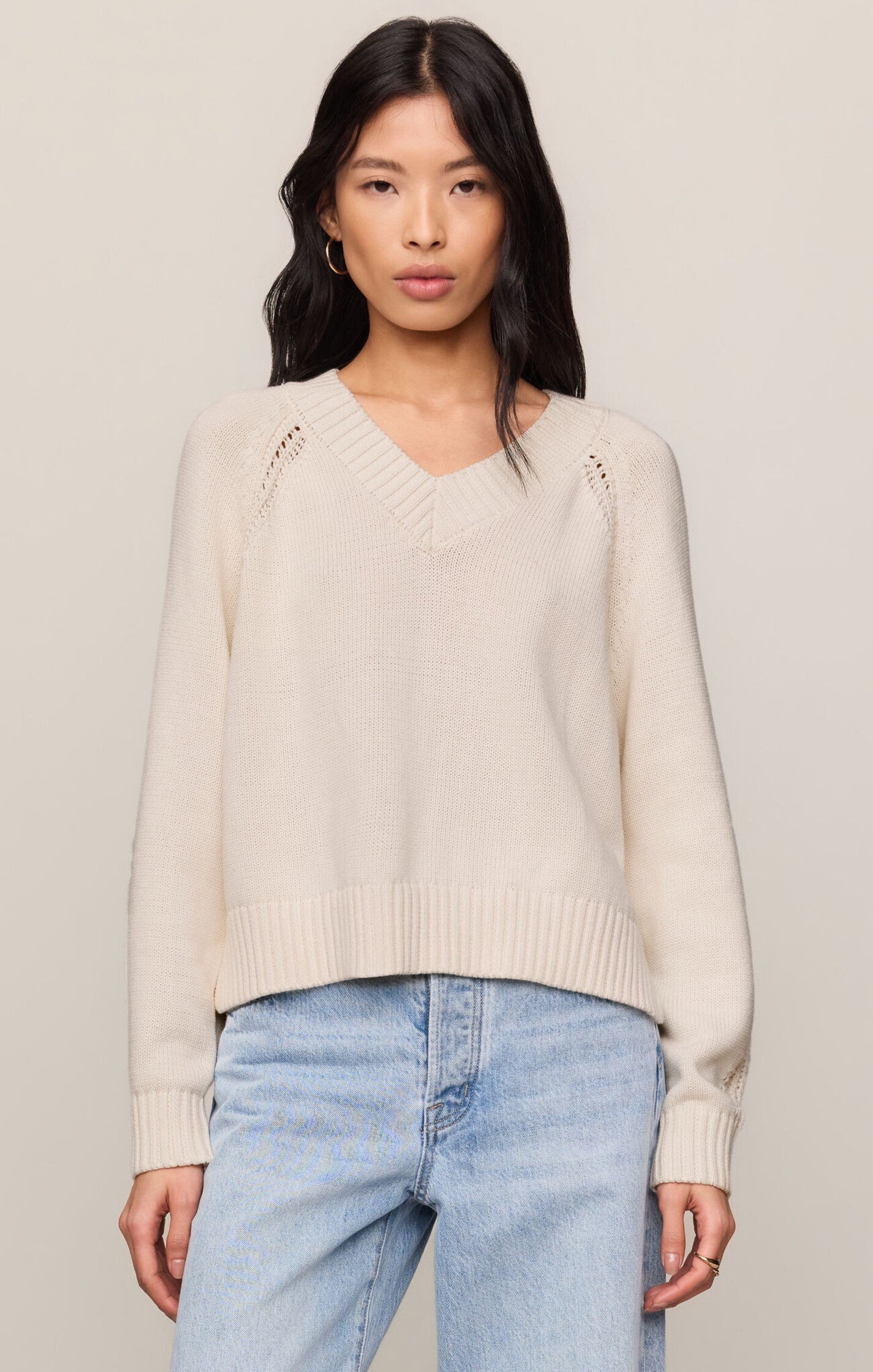 Model wearing the Z Supply Stratton V-Neck Sweater in Sandstone, featuring a V-neckline, long sleeves, and a soft cotton knit in a neutral beige hue.