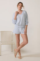 Model wearing a sky-blue V-neck sweatshirt with long sleeves, ribbed cuffs and hem, and a relaxed fit.
