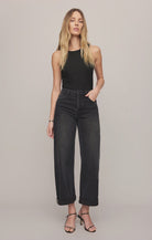 High-rise washed black jeans featuring a relaxed bowed-leg silhouette, full-length hem, and contrast whipstitch detailing inside the cuff.

