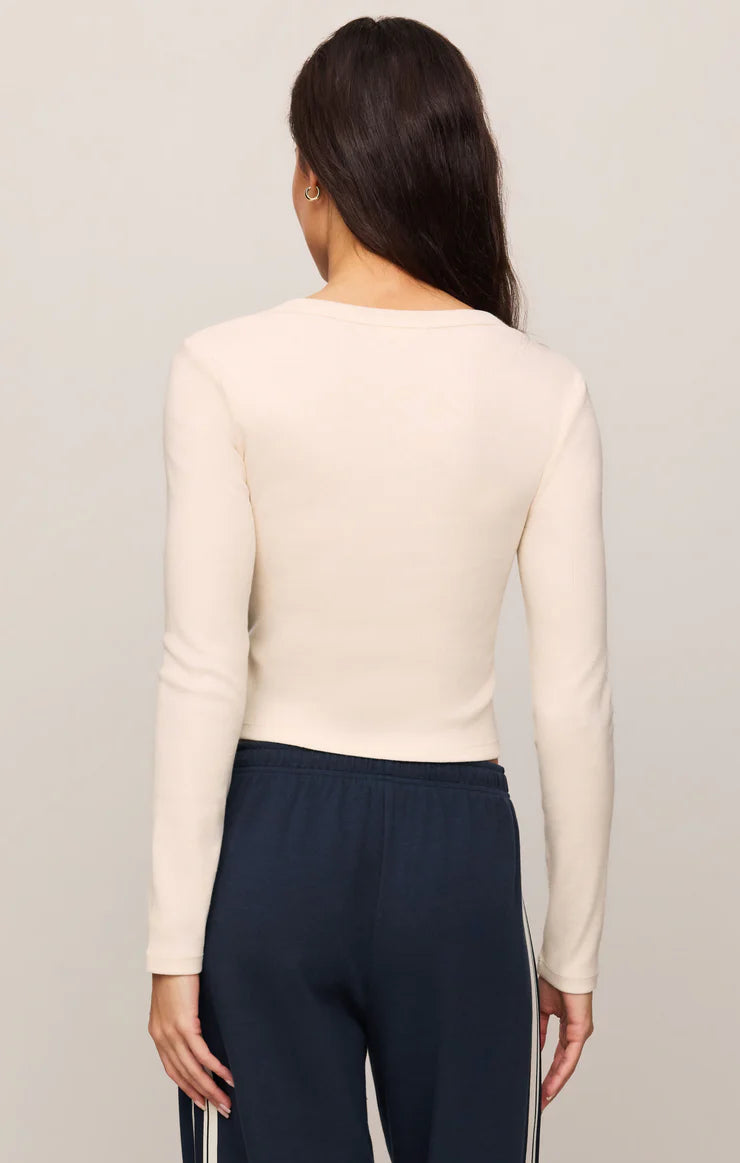 Fitted long-sleeve henley top in soft cotton modal rib fabric with a cropped silhouette, henley neckline, and functional button-front placket. The comfortable stretch fabric creates a flattering fit, making it ideal for casual wear, layering, or pairing with workout-inspired outfits.
