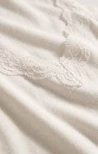 Fitted baby rib cotton tank with a lace-trimmed V-neckline and wide straps. A soft, feminine essential that's perfect for layering or wearing on its own.